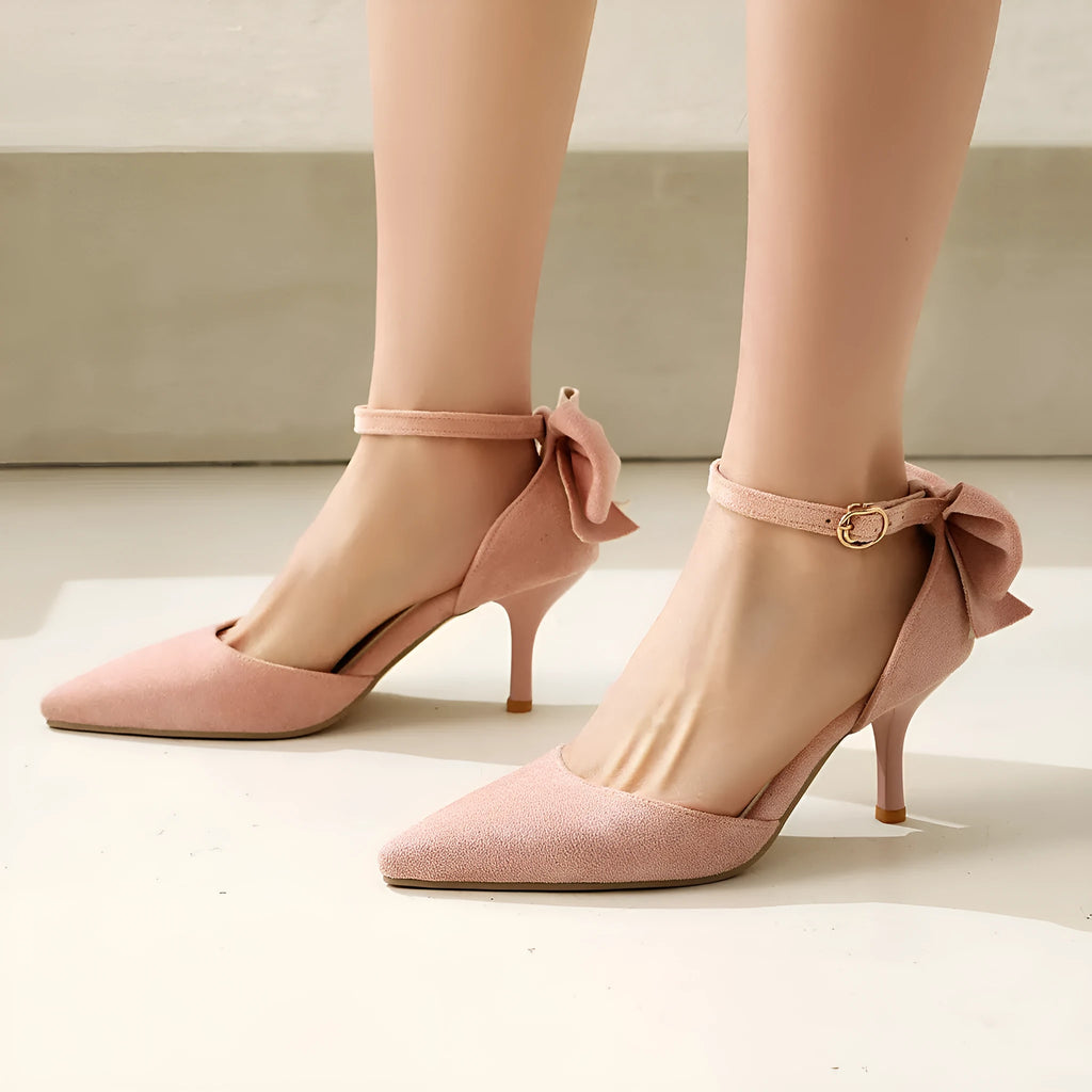 Black suede pointed-toe stiletto high heels with a bowknot detail and buckle ankle strap.