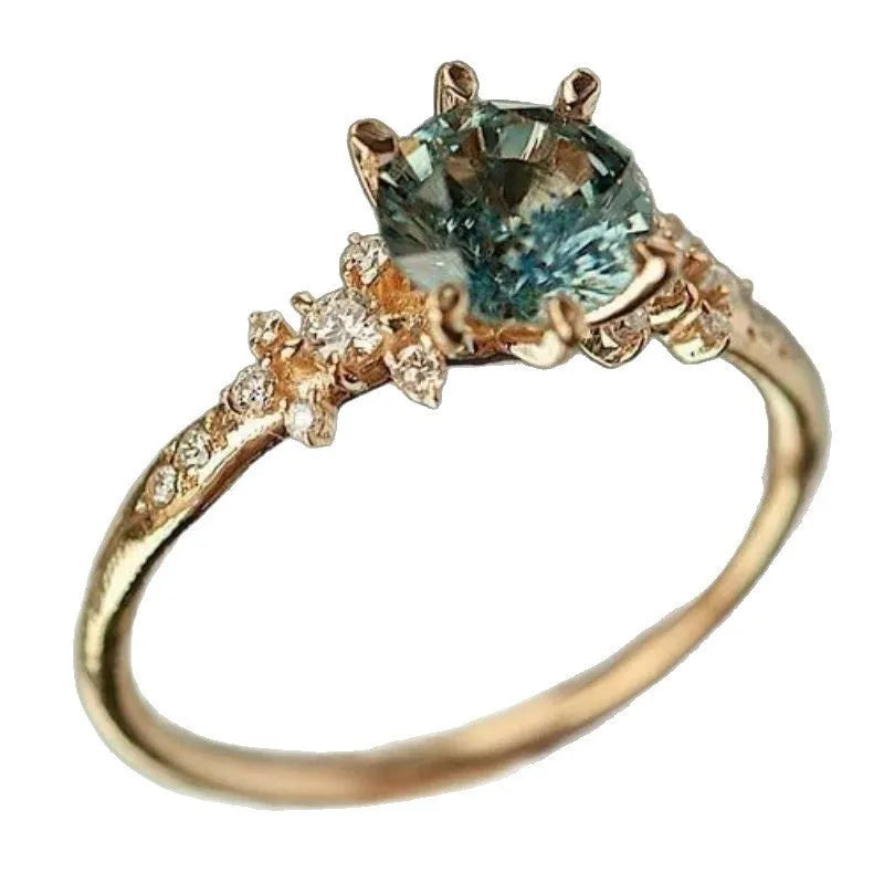 Gold plated geometric ring with a claw-set zircon stone on a chamfered square pattern band.