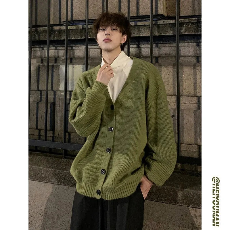 Men's loose fit V-neck cardigan sweater in a solid colour on a hanger.