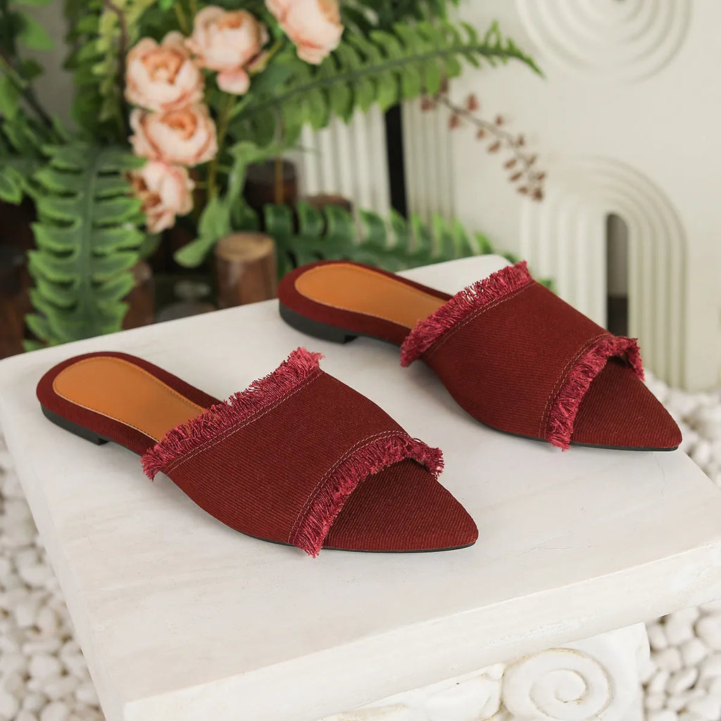 Women's denim casual flat slipper with tassel detail in various colours on a white background.
