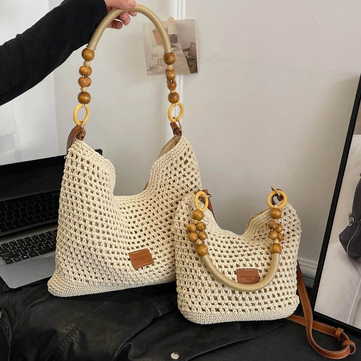 Knitted tote beach bag showing bucket shape, contrast stitching, and zippered internal pocket in black colour