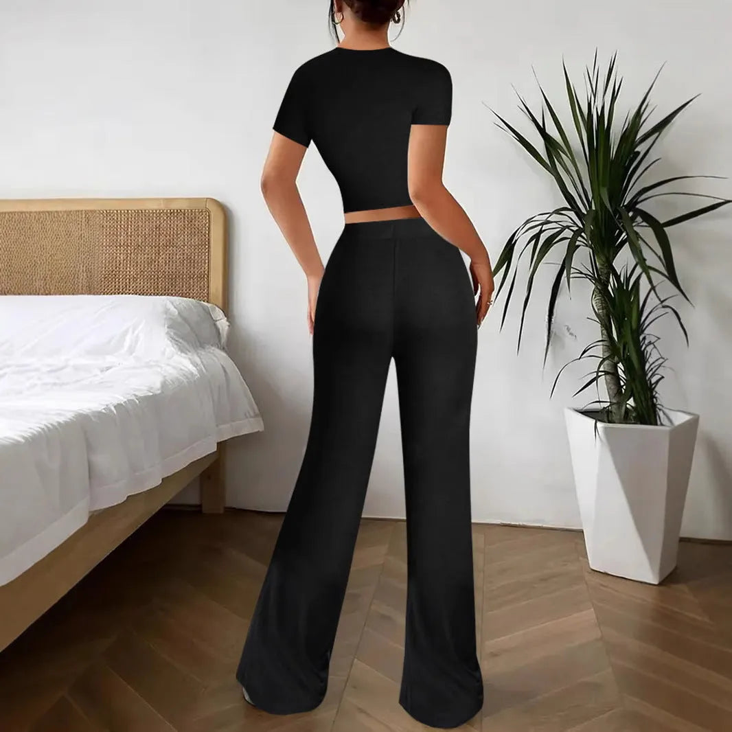 Black high-waist trousers and short-sleeve T-shirt co-ord set laid flat.