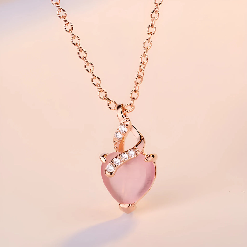 Rose gold women's necklace with a pink artificial crystal heart-shaped pendant on a cross chain
