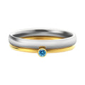 Gold tone titanium steel ring with a blue December birthstone and engraved geometric band.