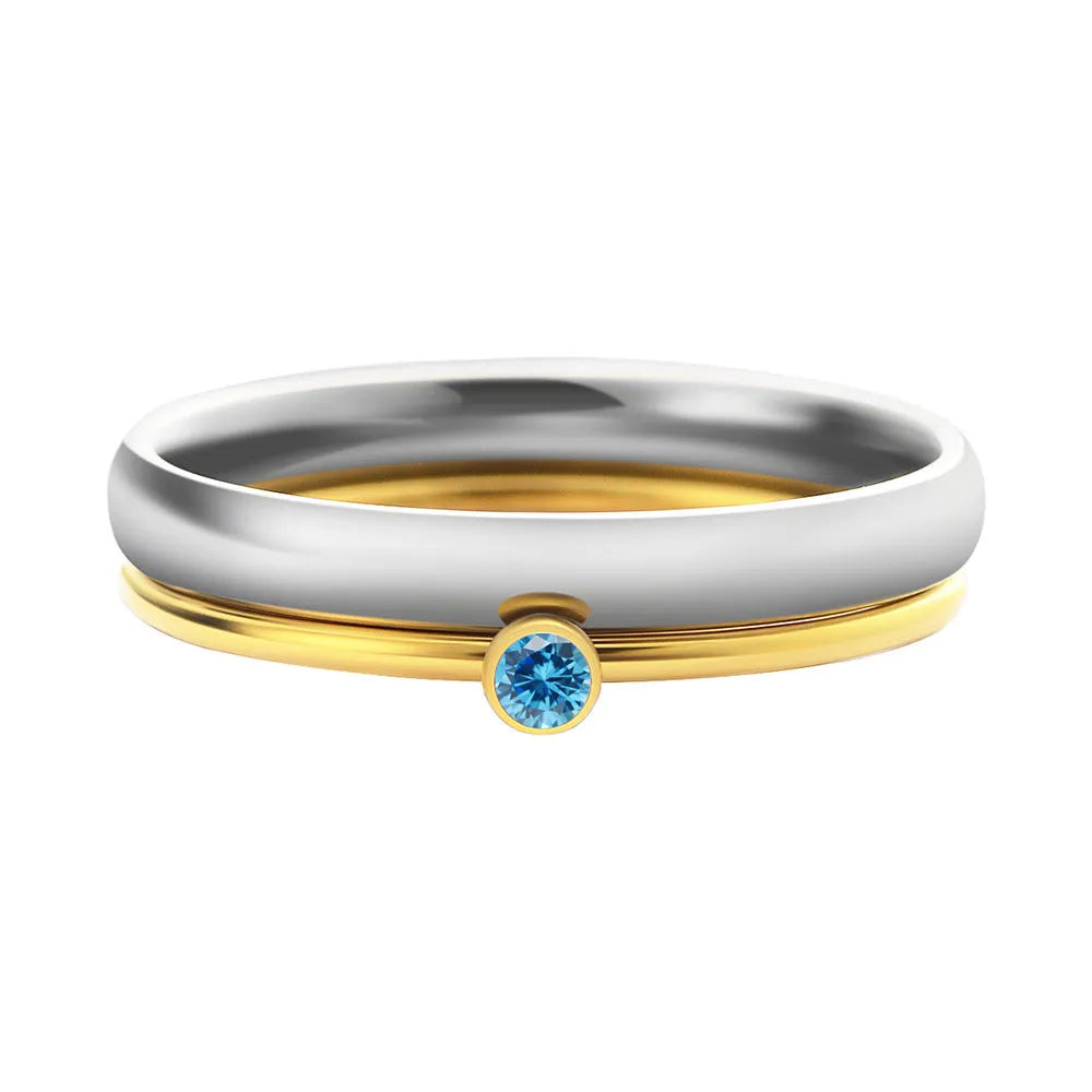 Gold tone titanium steel ring with a blue December birthstone and engraved geometric band.
