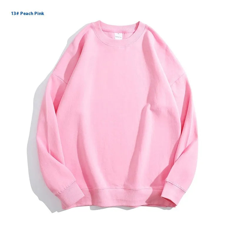 A woman wearing a loose-fit, off shoulder, long sleeve cotton pullover sweater in a solid colour.