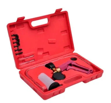 Manual aluminium vacuum air blow gun car dent repair tool on a workshop bench.