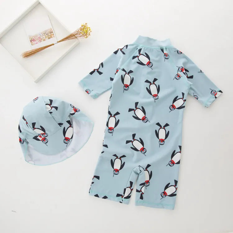 Boys' long sleeve penguin print swimsuit and matching swim cap set on a white background.