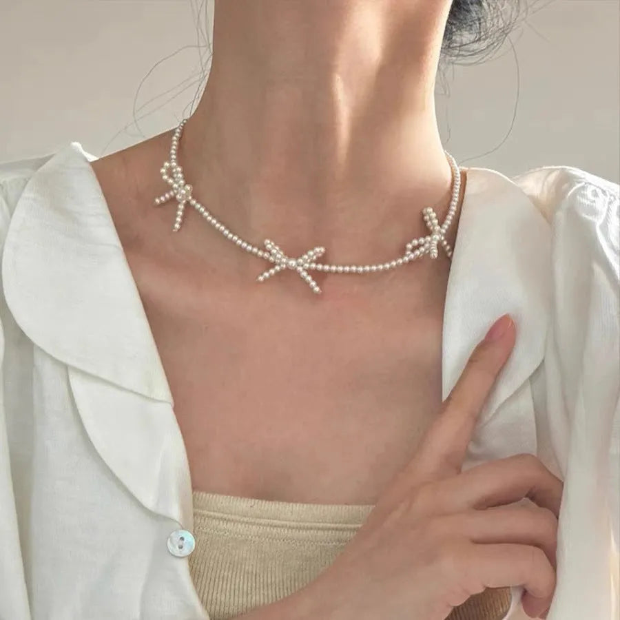 White imitation pearl necklace with bow-shaped pendant on adjustable 31-40 cm chain