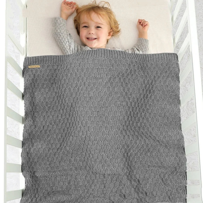 Solid colour infant hug blanket with textured lines in acrylic fabric