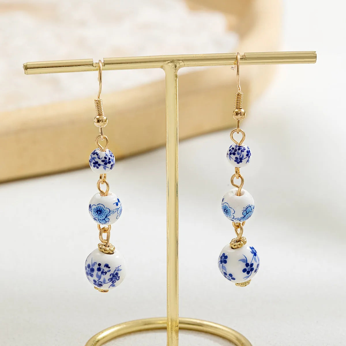 Long retro earrings with blue and white porcelain-coloured ceramic beads and geometric alloy details.